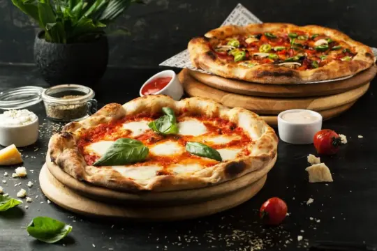 Dwa pyszne pizze, idealne na **dzień pizzy**. Jedna klasyczna Margherita, druga z warzywami i salami.