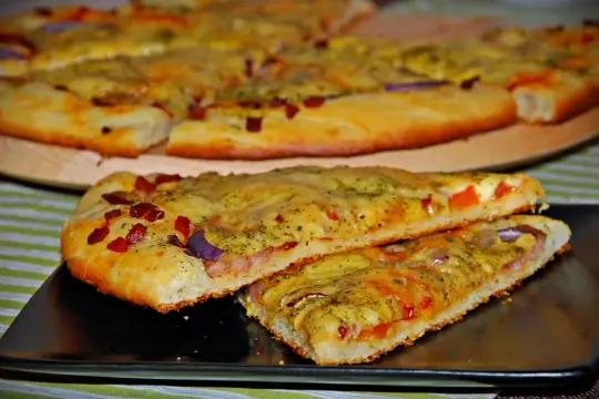 Jak zrobić pizzę? Zobacz, jak pysznie wygląda ta domowa pizza z boczkiem, cebulą i serem. Idealna na szybki obiad!