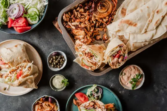 Pyszne gyros składniki: mięso, warzywa, sosy i chlebki pita. Idealne do domowego przygotowania.