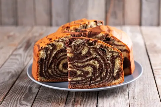 Pyszne ciasto z airfryer w paski, jak zebra, na szarym talerzu, prezentuje się apetycznie.