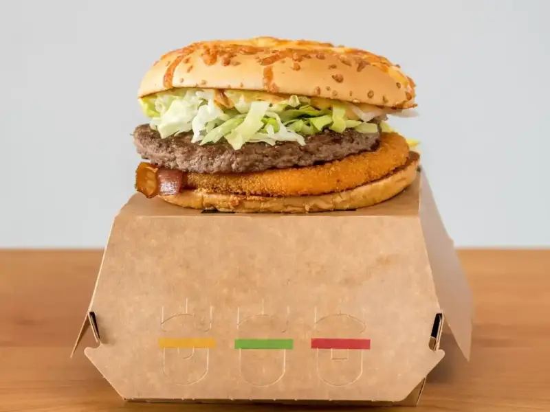 Drwal z chrzanem: soczysty burger z chrupiącym plackiem, sałatą i bekonem, podany w ekologicznym opakowaniu.