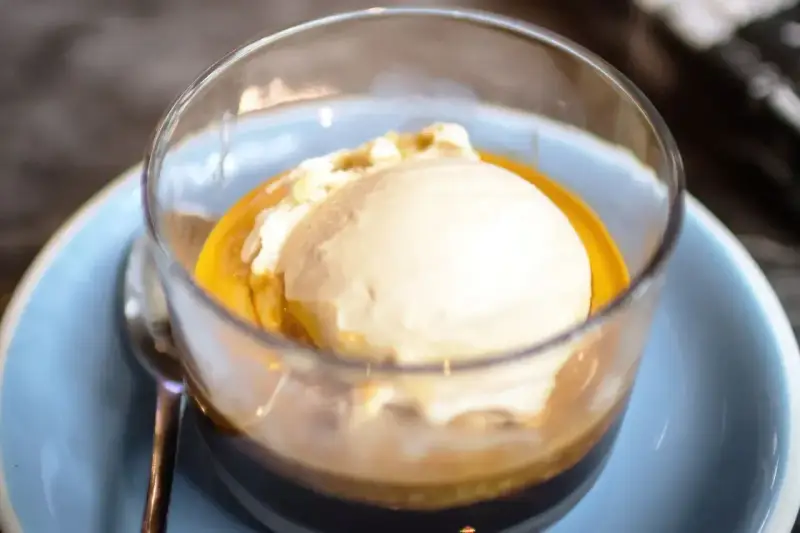 Pyszna gałka lodów waniliowych pływa w aromatycznym espresso. Idealne połączenie słodyczy i goryczy.